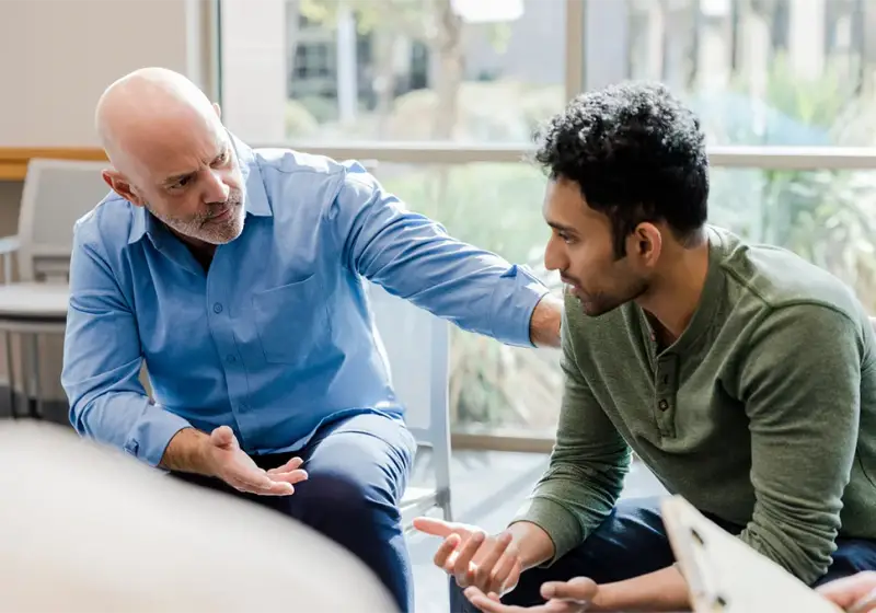 Counselor listening to an adult client in a bright room