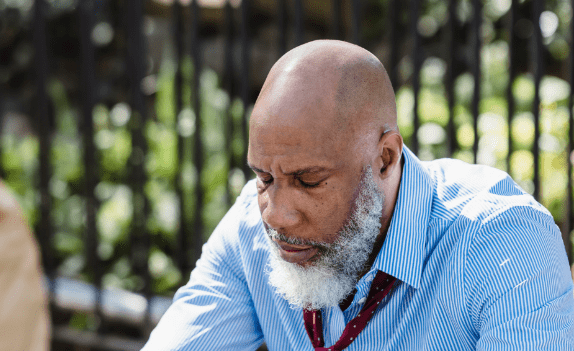 man sitting down looking at the ground for Substance abuse anger management