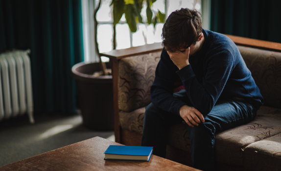 person sitting on a couch in need of dual diagnosis treatment