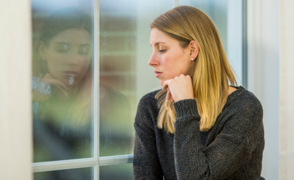 girl looking out a window in need of dual diagnosis treatment